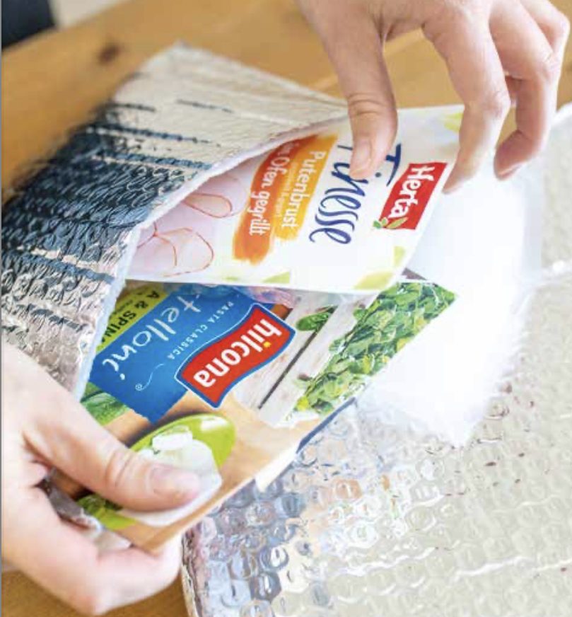 Ware wird mit Kühlung in eine Isoliertasche gepackt